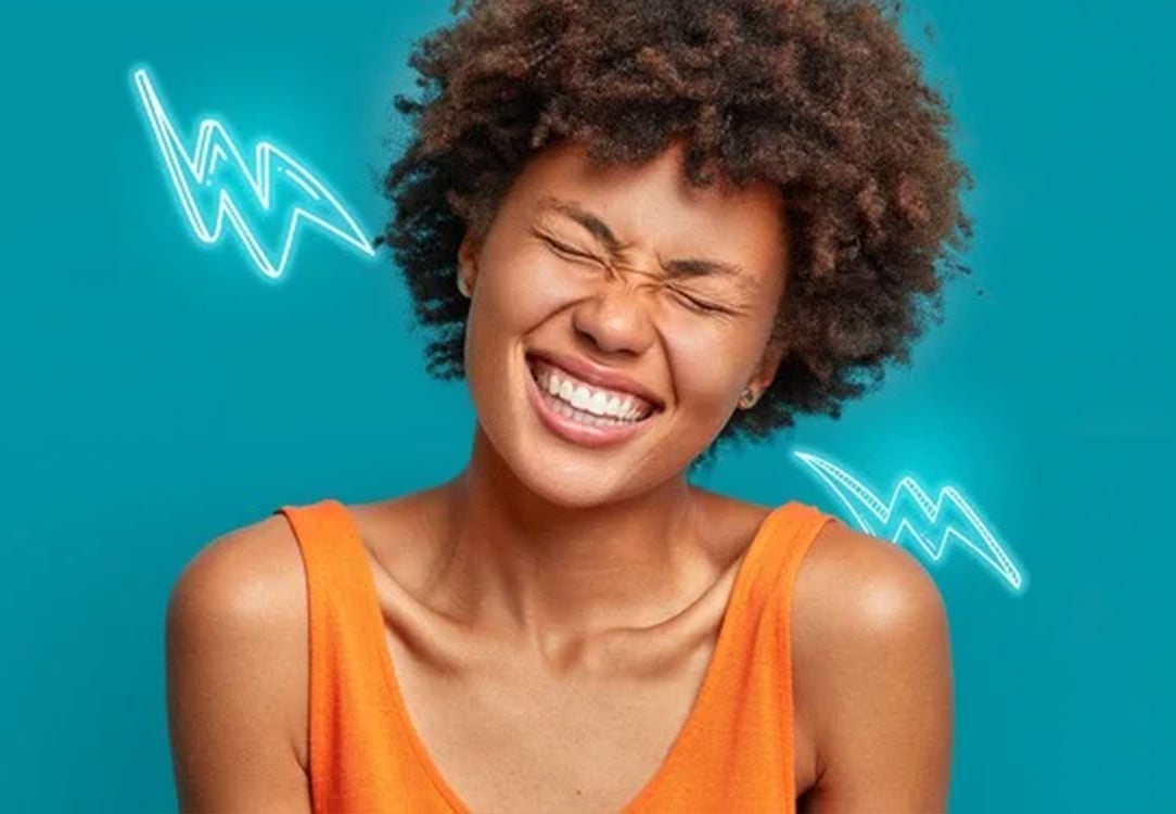 Stock photo of woman with eyes closed wearing an orange tank top on a teal background with lighting bolts