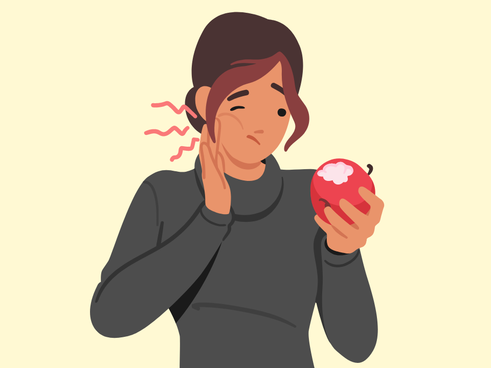Woman holding cheek in pain after biting apple