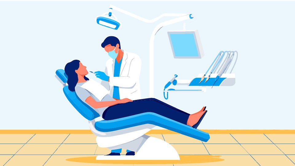 woman sitting on full dental chair setup while dentist works on their teeth