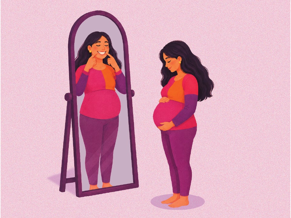 pregnant woman looking to a mirror with a smiling face